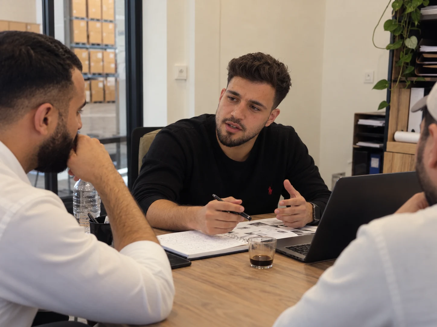 Three colleagues in a natural working discussion around an office table